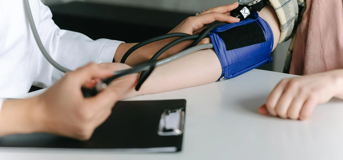 Tensiomètre électronique ou manuel : lequel est fait pour vous ? 17 Tensiomètre - Médecin prenant la tension artérielle d’un patient avec un tensiomètre manuel à brassard bleu dans un cadre de consultation.