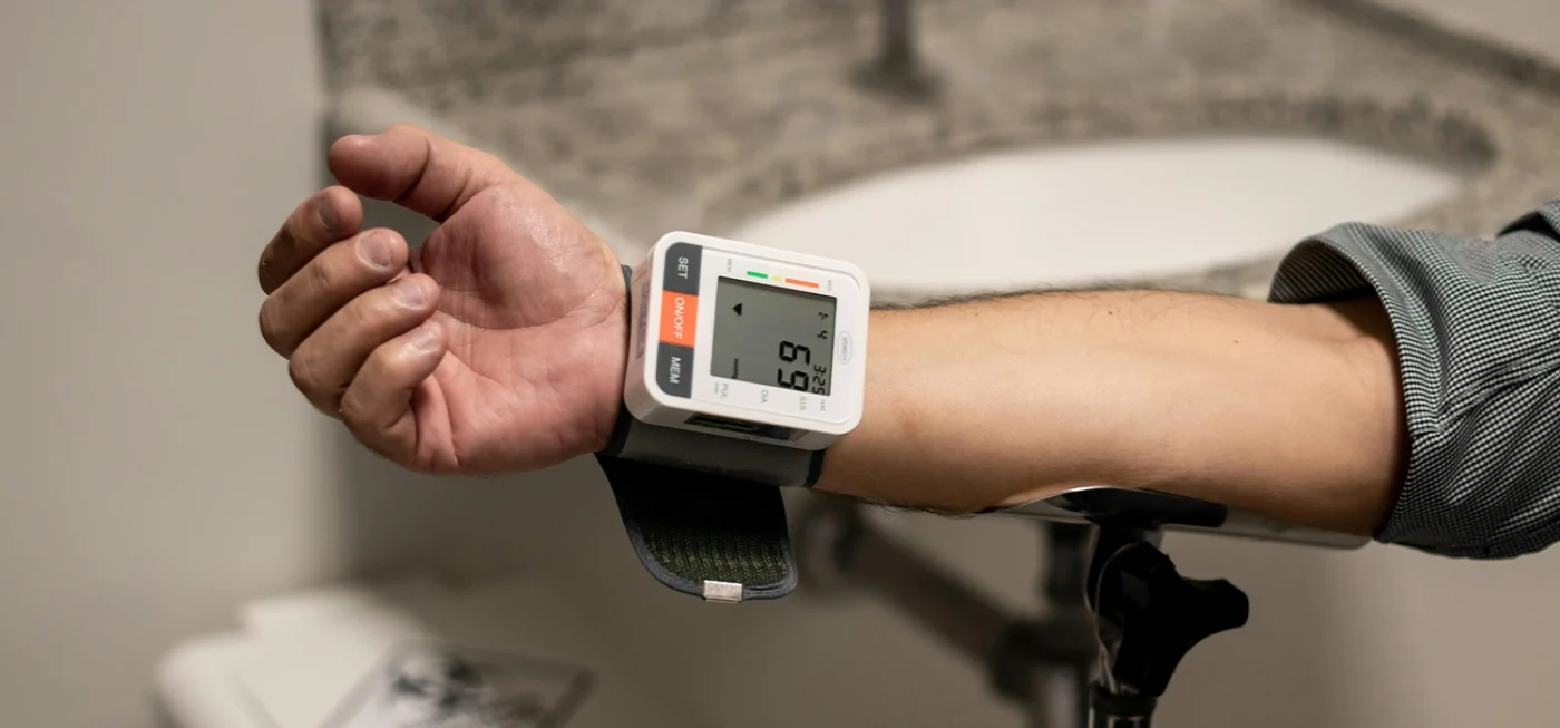 Comment utiliser un tensiomètre correctement pour des résultats fiables ? 4 Mesure de la tension artérielle avec un tensiomètre électronique au poignet dans une salle de bain.