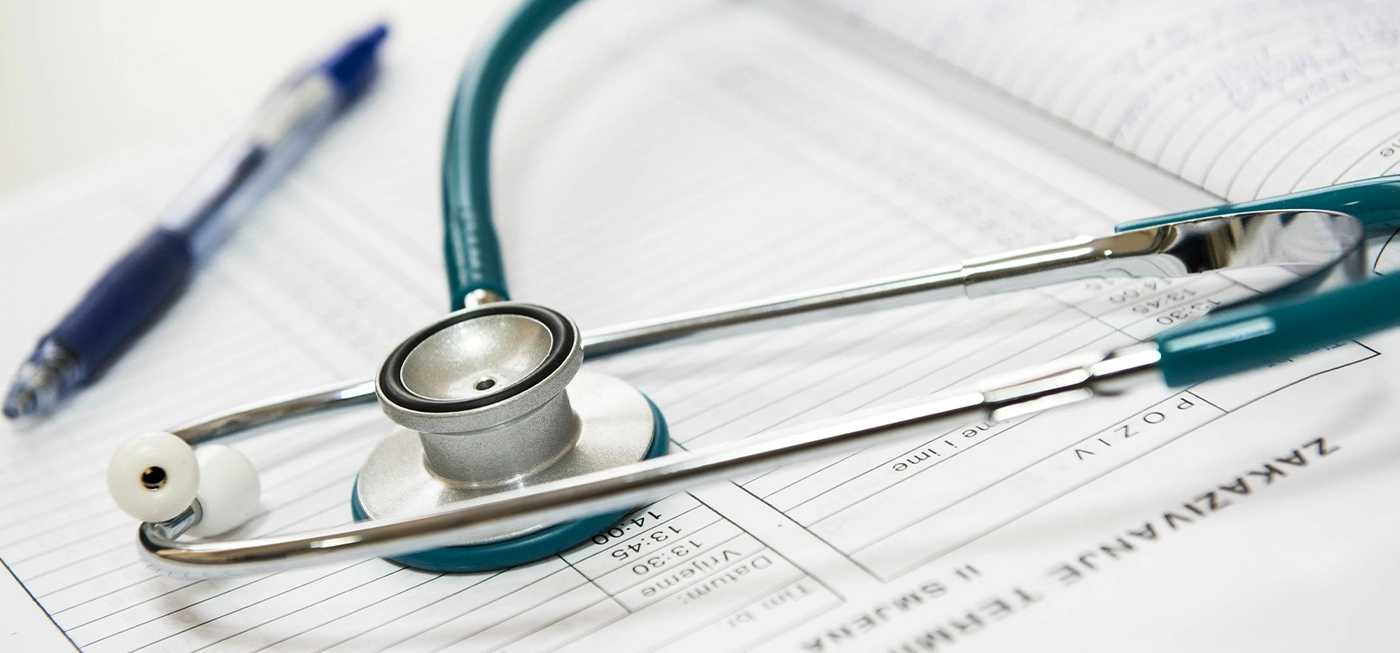 Comment bien choisir son matériel médical en 2025 ? Le guide expert. 3 Stéthoscope posé sur un dossier médical avec un stylo, représentant du matériel médical utilisé par les professionnels de santé.